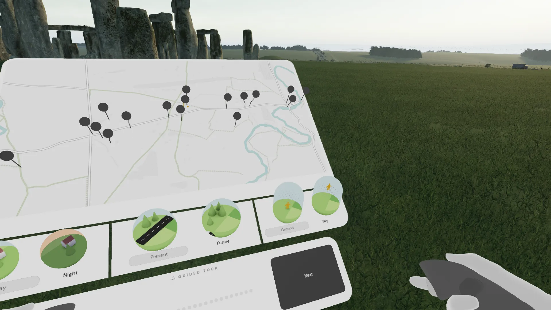 A virtual first person view of a map held up in front of Stonehenge.
